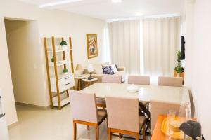 une salle à manger et un salon avec une table et des chaises dans l'établissement Flat em Resort Beira Mar na Praia de Búzios - Qavi, à Pirangi do Sul