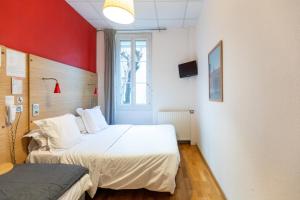 een slaapkamer met 2 bedden en een rode muur bij Hôtel Edmond Rostand in Marseille