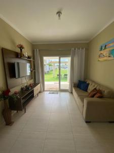 a living room with a couch and a television at Boas Vistas Canoa Quebrada in Aracati