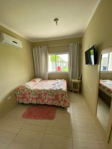 a small bedroom with a bed and a window at Boas Vistas Canoa Quebrada in Aracati