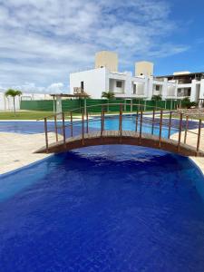 a wooden bridge over a pool of blue water at Boas Vistas Canoa Quebrada in Aracati +4 photos