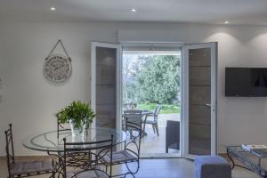 sala de estar con mesa de cristal y reloj en Domaine Ghjulia en Patrimonio