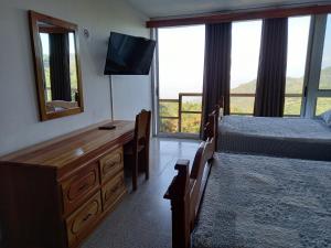a bedroom with a bed and a dresser with a television at Vista Encantada in Villa Canales