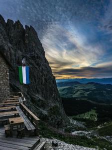 a flag hanging on the side of a mountain at Cèsa Prinoth in Campitello di Fassa