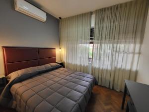 - une chambre avec un lit et une grande fenêtre dans l'établissement Salta Avenida Belgrano Habitaciones Alojamiento Familiar, à Salta
