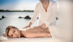 a woman getting a back massage on the beach at The Pelican Beach Resort & SPA - Adults Only in Olbia