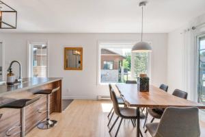 a kitchen and dining room with a wooden table and chairs at INITIAL - KOALA - Mont-Sainte-Anne in Beaupré +24 photos