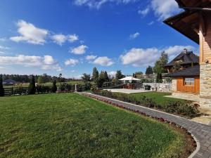 einen Hinterhof mit Rasen und einem Gebäude in der Unterkunft Vila Engelshof - Zlatibor in Zlatibor