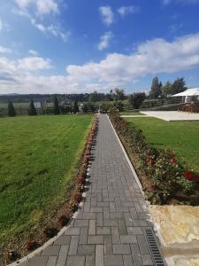 a brick walkway in a park with flowers at Vila Engelshof - Zlatibor in Zlatibor