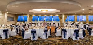 una sala de banquetes con mesas y sillas en una habitación con ventanas en Holiday Inn Des Moines-Downtown-Mercy Campus, an IHG Hotel en Des Moines