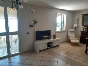 ein Wohnzimmer mit einem Flachbild-TV an der Wand in der Unterkunft Villa il Carrubo in Licata