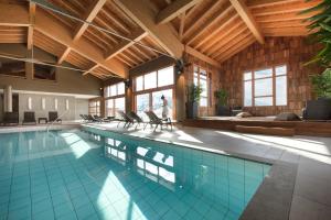 een groot zwembad in een gebouw bij ILY Hotels La Rosiere in La Rosière