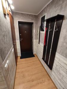 ウファにあるApartment Prospekt Oktyabrya 103の黒いドアと木製の床の廊下