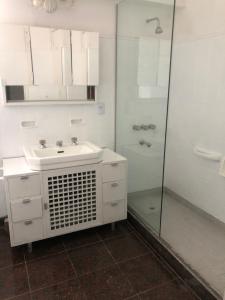 ein weißes Badezimmer mit Waschbecken und Dusche in der Unterkunft El Descanso in Villa Giardino