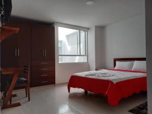 a bedroom with a bed and a desk and a window at Hotel Prestigio JC in Sogamoso
