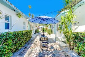un patio con due sedie e un ombrellone di Cottages El Portal a Miami