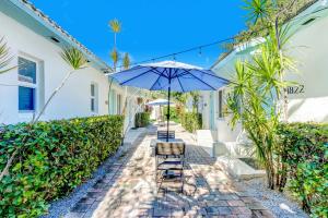 a patio with two chairs and an umbrella at Cottages El Portal in Miami