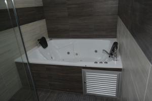 a bath tub with a shower and a sink at Hotel Prestigio JC in Sogamoso