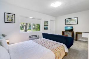 a bedroom with a bed and a desk and a window at Cottages El Portal in Miami