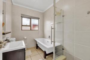 a bathroom with a tub and a sink and a shower at Smartz Apartment 76 in Midrand +5 photos
