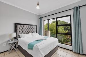 a bedroom with a bed and a large window at Smartz Apartment 76 in Midrand