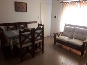 sala de estar con sofá, mesa y sillas en Tandil Centro en Tandil