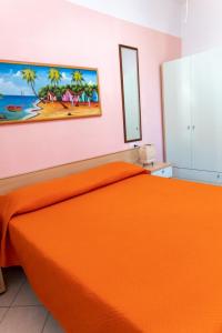 ペスキチにあるVilla Marilenaのベッドルーム1室(オレンジ色のベッド1台付)が備わります。壁には絵画が飾られています。