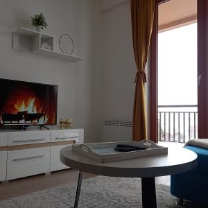 sala de estar con TV y mesa en Pahuljica en Kupres