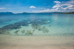 a person swimming in the water in the ocean at The Pelican Beach Resort & SPA - Adults Only in Olbia