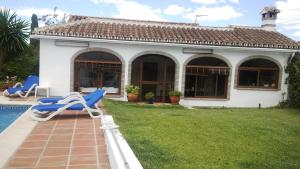 ein Haus mit einem Garten mit einem Pool und einem Stuhl in der Unterkunft Casacool in Málaga