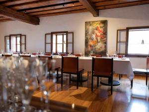a large room with tables and chairs and a painting at Mesnerhaus & Gourmetrestaurant Mesnerhaus mit 4 Hauben in Mauterndorf