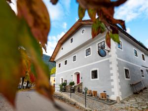 a white building with a clock on it at Mesnerhaus & Gourmetrestaurant Mesnerhaus mit 4 Hauben in Mauterndorf