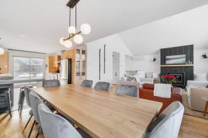 uma sala de jantar e sala de estar com uma mesa de madeira e cadeiras em INITIAL - Chalet FAMILIA SENSE - Mont-Sainte-Anne em Saint-Férréol-les-Neiges