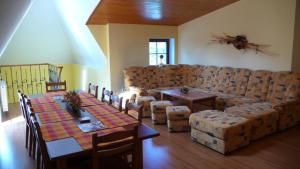 a living room with a couch and a table and chairs at Penzion Padrtův mlýn in Třebíč