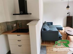 uma sala de estar com um sofá azul e uma mesa em Ferienhaus Robert em Weisswasser