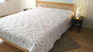 a bed with a white comforter on it in a bedroom at FSQH SECRET TOWER in Szeged
