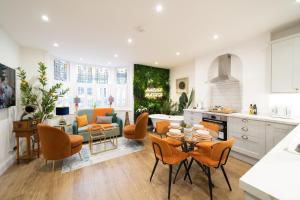 een keuken en een woonkamer met een tafel en stoelen bij The House Of Selfies in Royal Tunbridge Wells