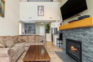 a living room with a couch and a fireplace at 2BR Slopeside in Chateau Ridge Blue Mountains in Blue Mountains