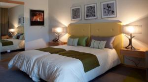 1 dormitorio con 1 cama blanca grande y 2 lámparas en Hotel Santa Margarida en Oleiros