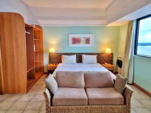 a hotel room with a bed and a couch at Flat no Tropical - Linda Vista da Praia in Manaus