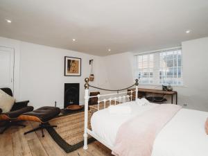 a bedroom with a bed and a chair and a fireplace at Pass The Keys Stylish 2 Bed Eco Flat in the heart of Bath in Bath