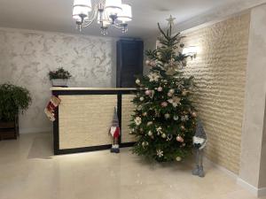 a christmas tree in a room with a fireplace at Pensiunea Romana in Onești