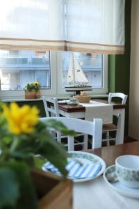 a dining room table with a sail boat in the window at heinrichs 4a in Norderney