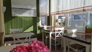 a dining room with white chairs and a table and a window at heinrichs 4a in Norderney