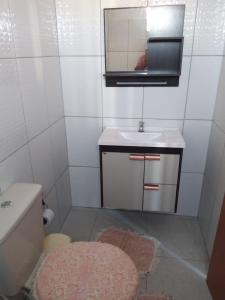 a bathroom with a sink and a mirror and a toilet at Pousada Emanuell in Ibicoara