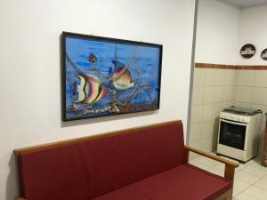 a picture hanging on a wall above a bench in a room at Casa beira mar Jacaraipe. in Serra