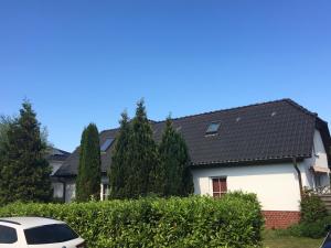 een wit huis met een zwart dak bij Feriendomizil an der Warnow in Rostock
