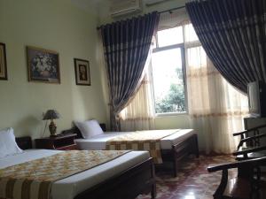 a hotel room with two beds and a window at Hai Trang Hotel in Ha Long