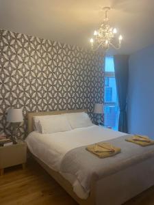 um quarto com uma cama e um lustre em Oswald Apartment - Glasgow City Centre em Glasgow