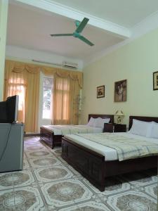 a bedroom with two beds and a ceiling fan at Hai Trang Hotel in Ha Long